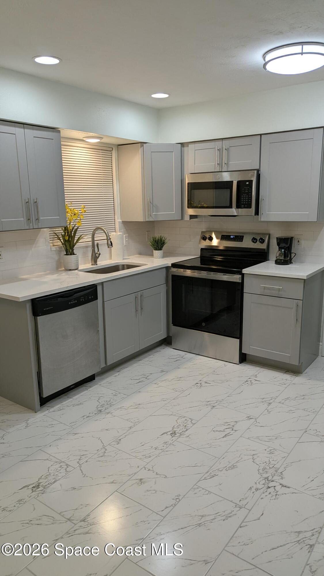 1616 Elizabeth Street Melbourne, FL 32901 - Photo 3 of 14 a large white kitchen with stainless steel appliances