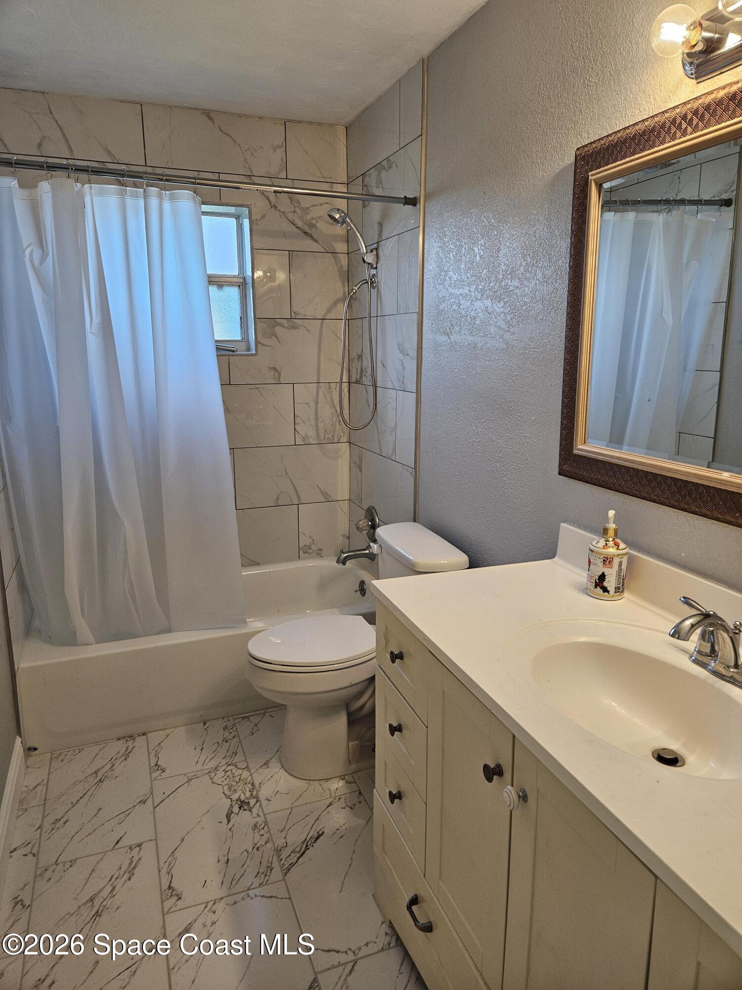 1616 Elizabeth Street Melbourne, FL 32901 - Photo 9 of 14 a bathroom with a sink a toilet and shower