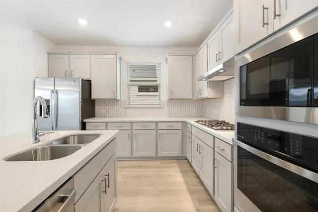 a kitchen with white cabinets and stainless steel appliances