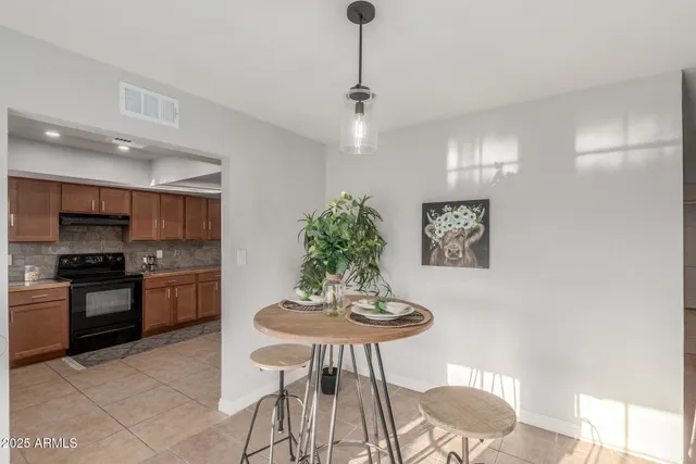 a kitchen with stainless steel appliances a dining table chairs and stove