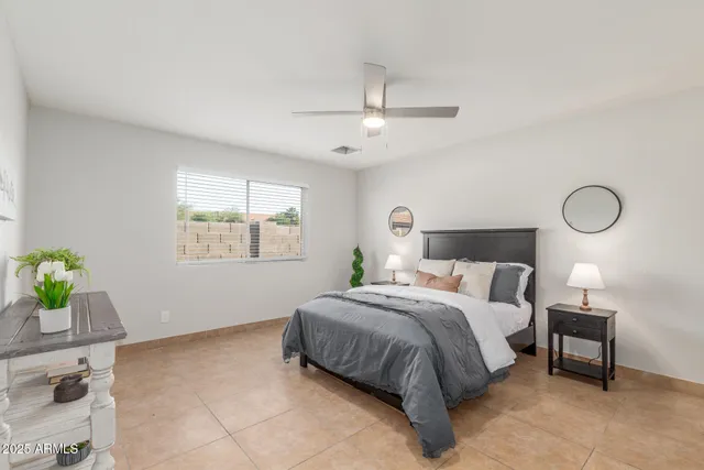 a bedroom with a bed chandelier and a window