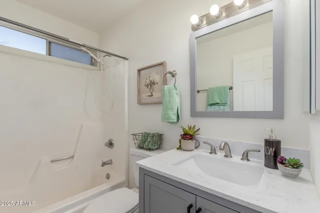 a bathroom with a sink vanity granite tub and shower