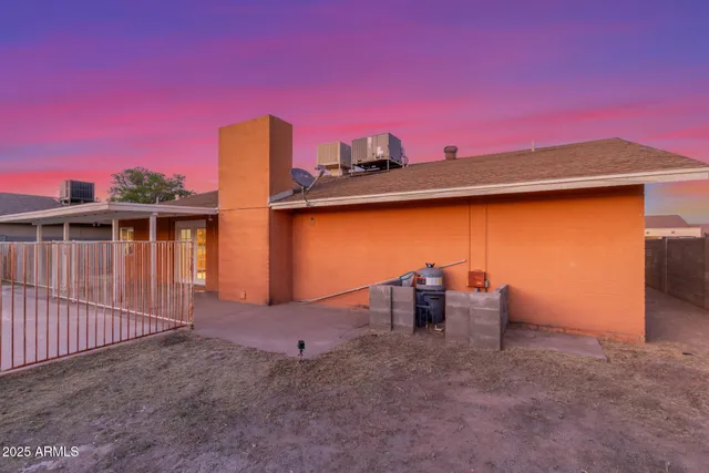 a backyard of a house with table and chairs