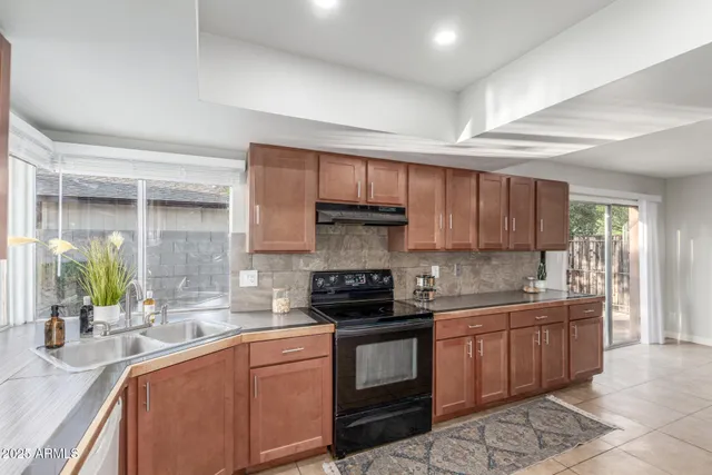 a kitchen with stainless steel appliances granite countertop a sink stove and cabinets