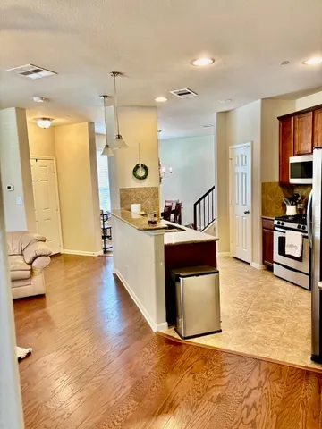 a living room with stainless steel appliances kitchen island granite countertop furniture and a kitchen view