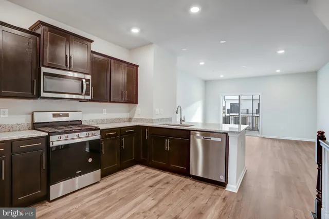 a kitchen with granite countertop wooden cabinets and stainless steel appliances