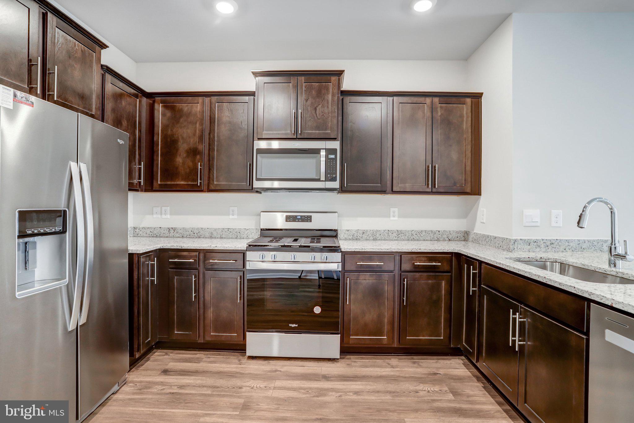 721 Courier Lane Frederick, MD 21701 - Photo 14 of 61 a kitchen with stainless steel appliances granite countertop a refrigerator stove and sink