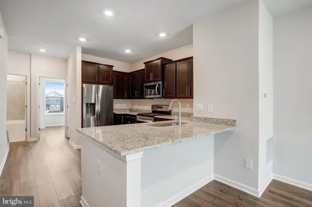 a view of kitchen and hall with wooden floor