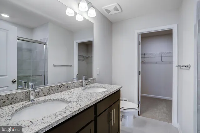 a bathroom with a granite countertop sink toilet and shower
