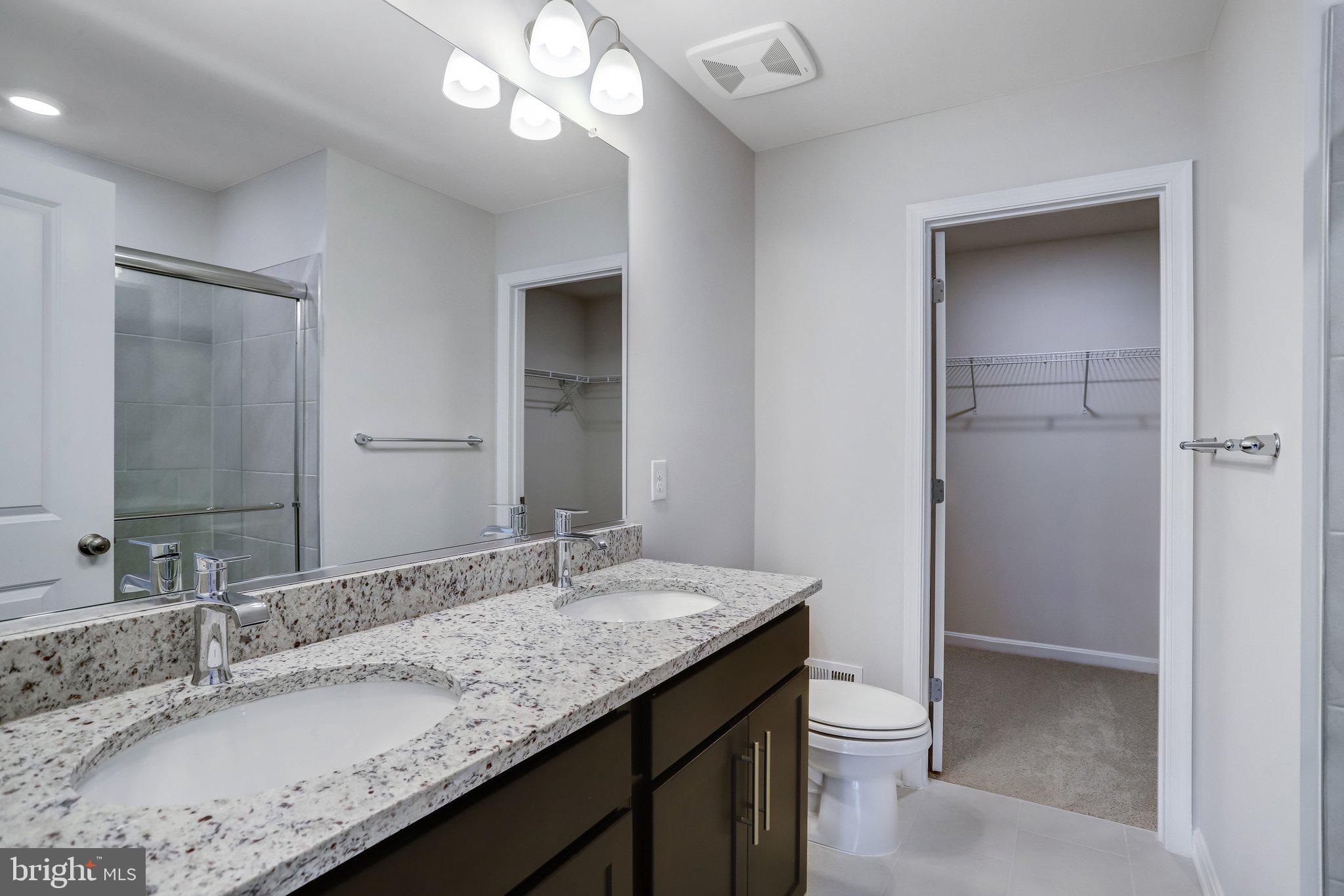 721 Courier Lane Frederick, MD 21701 - Photo 35 of 61 a bathroom with a granite countertop sink a toilet and a large mirror