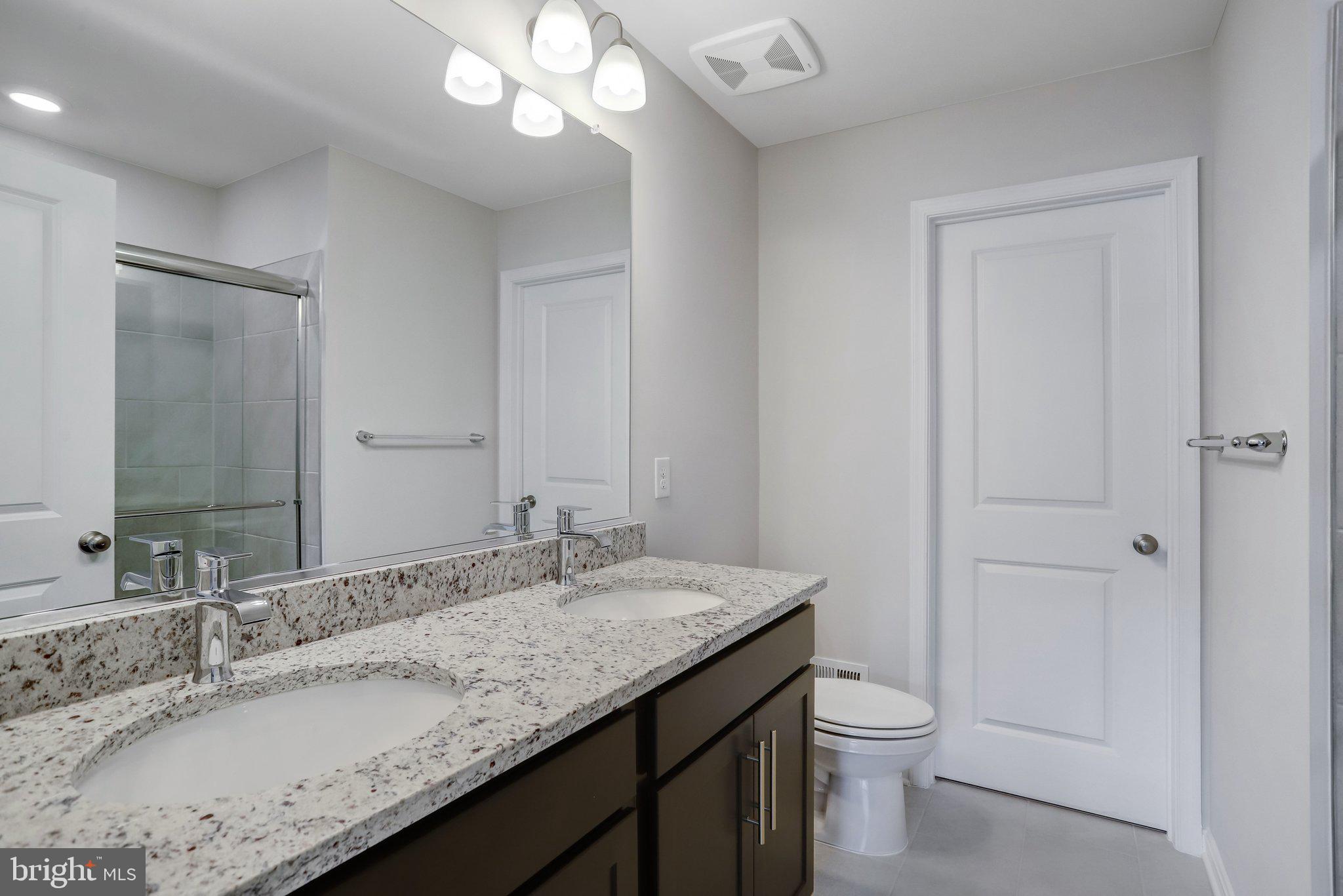 721 Courier Lane Frederick, MD 21701 - Photo 36 of 61 a bathroom with a granite countertop sink a toilet and a mirror