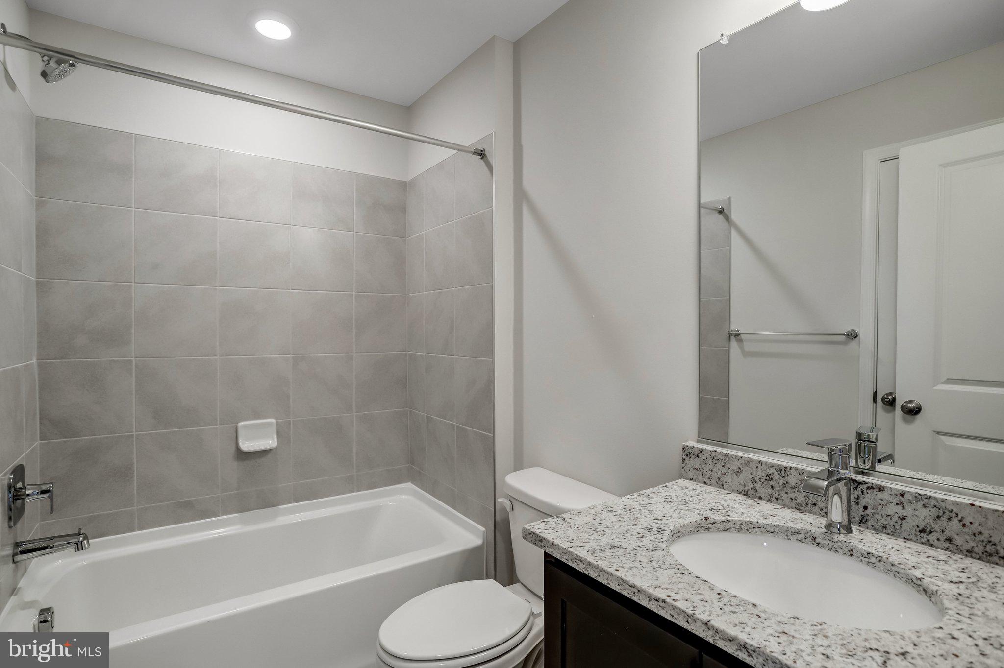 721 Courier Lane Frederick, MD 21701 - Photo 43 of 61 a bathroom with a granite countertop sink toilet and shower