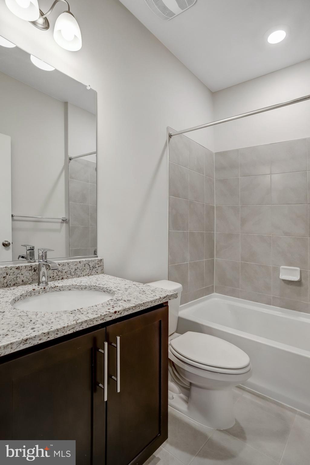 721 Courier Lane Frederick, MD 21701 - Photo 49 of 61 a bathroom with a granite countertop sink toilet and shower