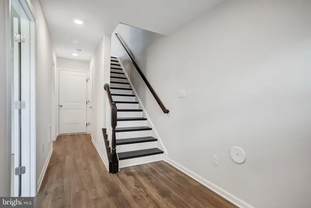 a view of a hallway with wooden floor and entryway