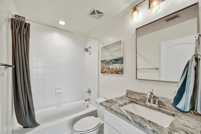 a bathroom with a granite countertop sink toilet and shower