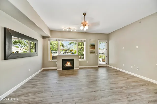 a view of an empty room with a window and fireplace