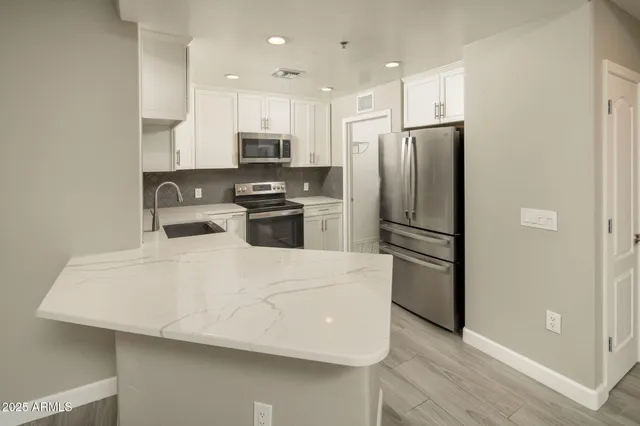 a kitchen with stainless steel appliances a refrigerator sink and microwave