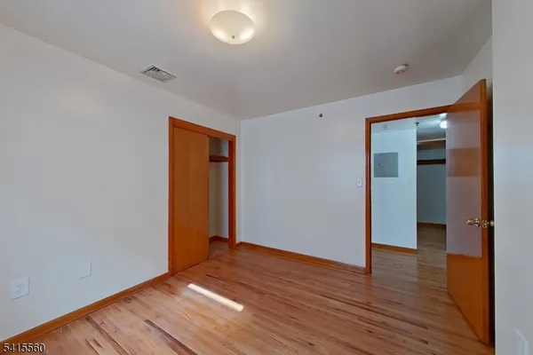 an empty room with wooden floor and closet