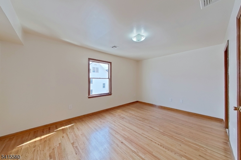 55 Ferguson Street, Unit 2 Newark, NJ 07105 - Photo 17 of 25 an empty room with wooden floor and windows