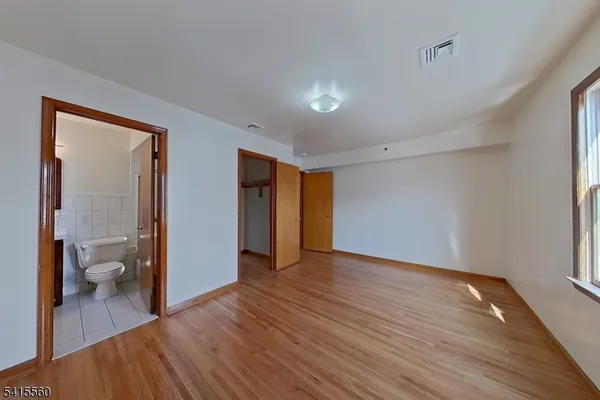 a view of a room with wooden floor and a bathroom