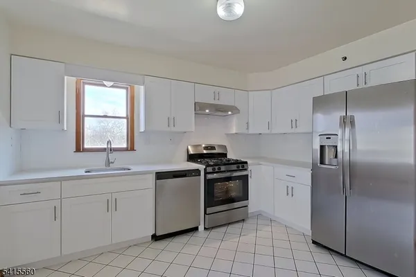 a kitchen with white cabinets stainless steel appliances and sink