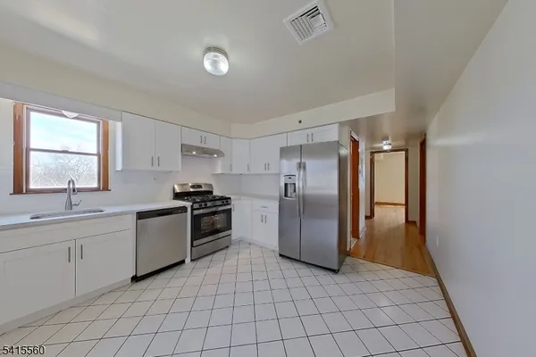 a kitchen with a refrigerator sink and cabinets