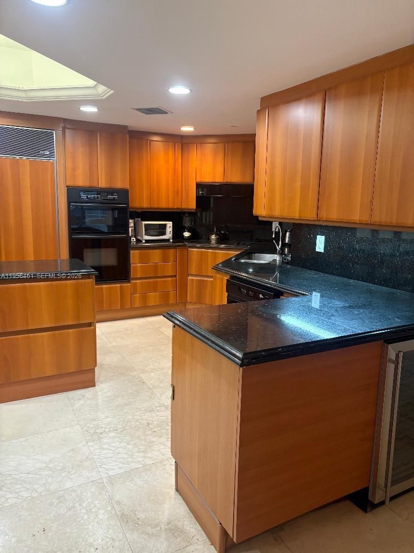 9595 Collins Avenue, Unit N9I Surfside, FL 33154 - Photo 7 of 9 a kitchen with stainless steel appliances a sink a stove a microwave a sink and cabinets