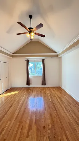 a view of an empty room with window and wooden floor