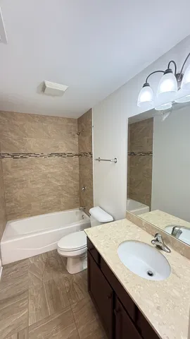 a bathroom with a granite countertop sink a toilet and bathtub