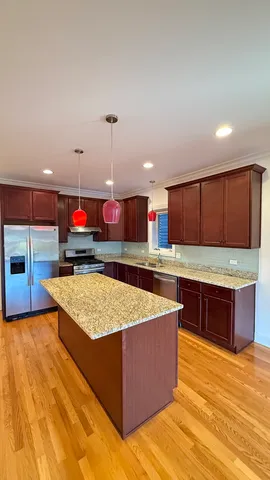 a kitchen with stainless steel appliances granite countertop a stove a sink and a refrigerator