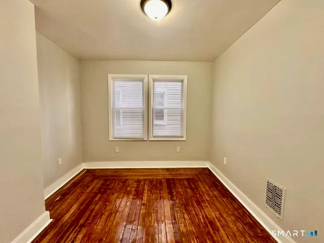 a view of a room with wooden floor and window