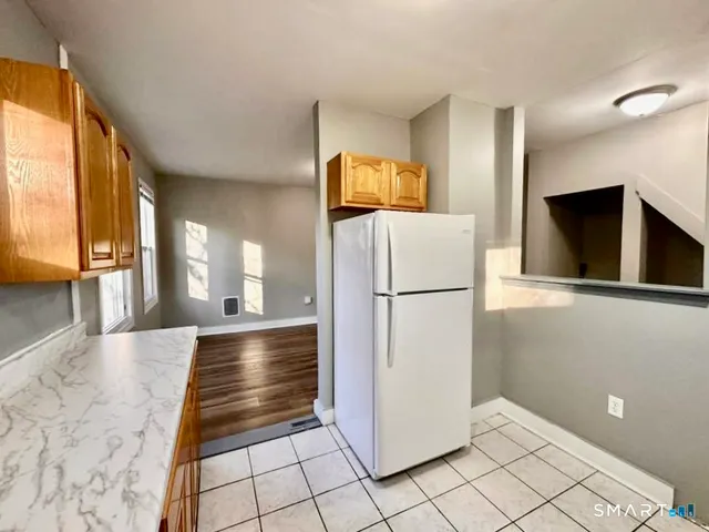 a view of a refrigerator in kitchen and a window