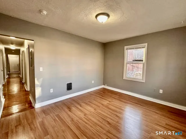 wooden floor in an empty room with a window