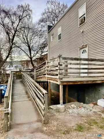 a view of a terrace with a barbeque and wooden stairs
