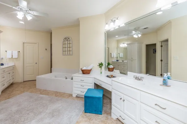 a spacious bathroom with a double vanity sink mirror and bathtub
