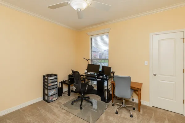 a view of a workspace with furniture and a window