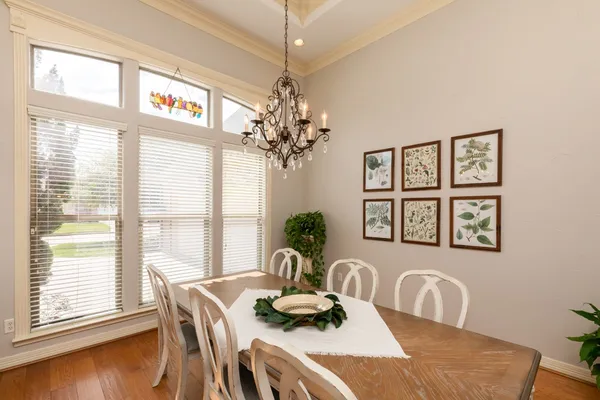 a dining room with furniture a large window and wooden floor