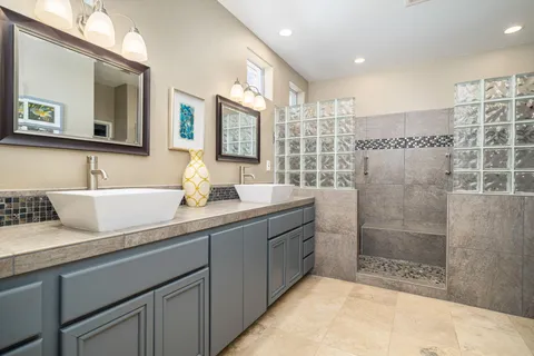 a bathroom with a double vanity sink mirror and shower