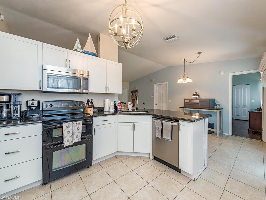 18351 Camellia Road Fort Myers, FL 33967 - Photo 5 of 11 a kitchen with stainless steel appliances granite countertop a stove and cabinets