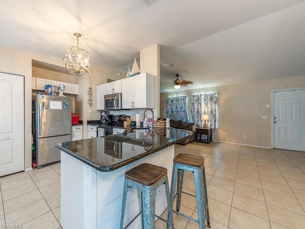 18351 Camellia Road Fort Myers, FL 33967 - Photo 6 of 11 a kitchen with stainless steel appliances granite countertop a sink a stove and a refrigerator
