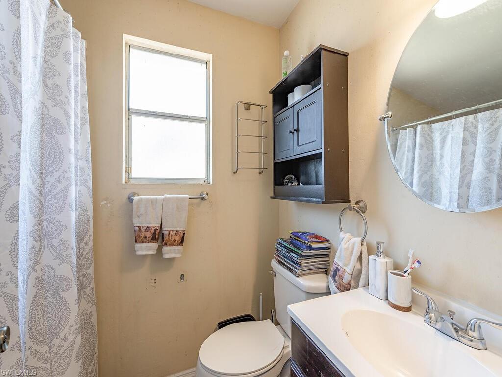 18351 Camellia Road Fort Myers, FL 33967 - Photo 8 of 11 a bathroom with a toilet a sink and a mirror