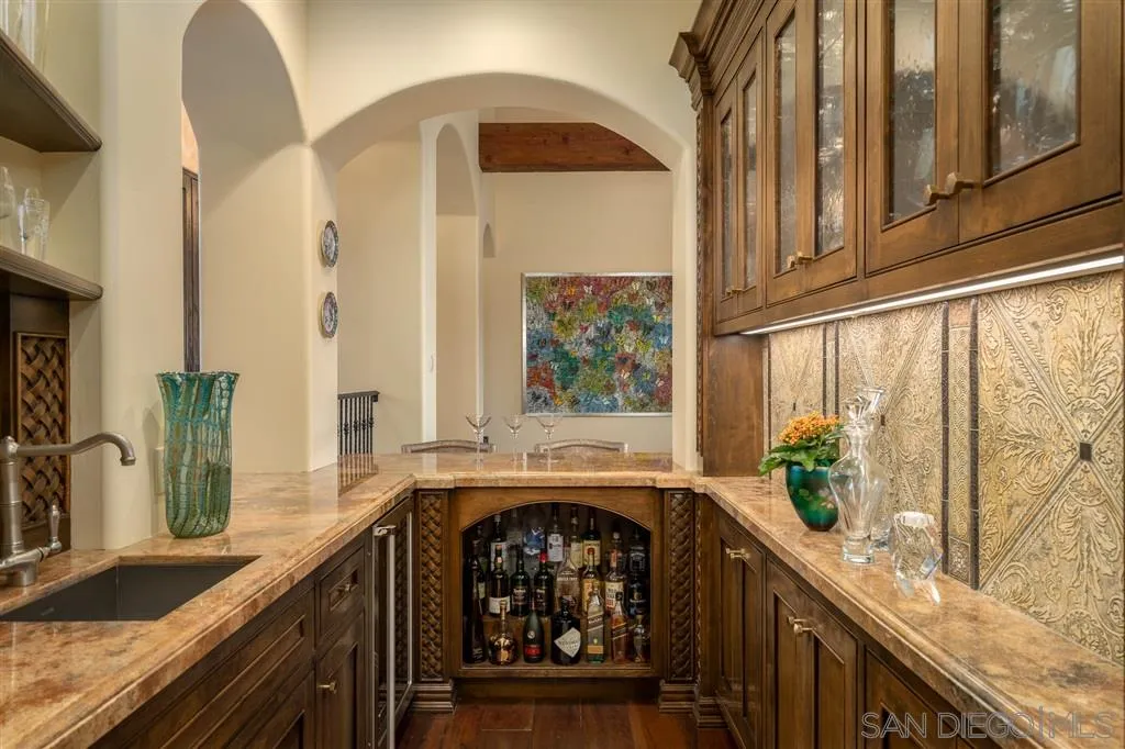 6266 Strada Fragante Rancho Santa Fe, CA 92091 - Photo 6 of 25 a kitchen with stainless steel appliances granite countertop a stove a sink and a large mirror