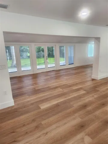a view of room with wooden floor and windows