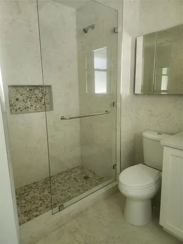 a bathroom with a toilet and a shower