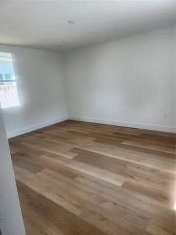 a view of a room with wooden floor and window