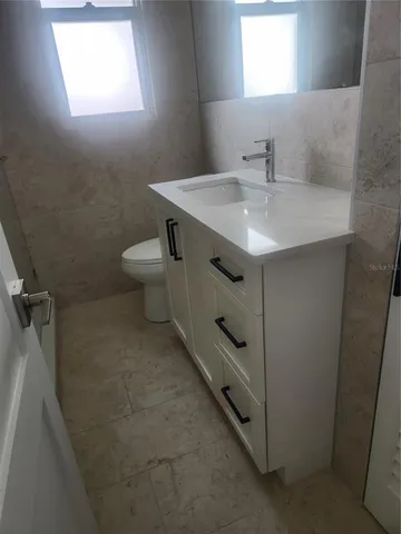 a bathroom with a sink toilet and window