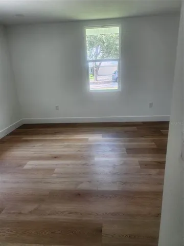 a view of a room with wooden floor and window
