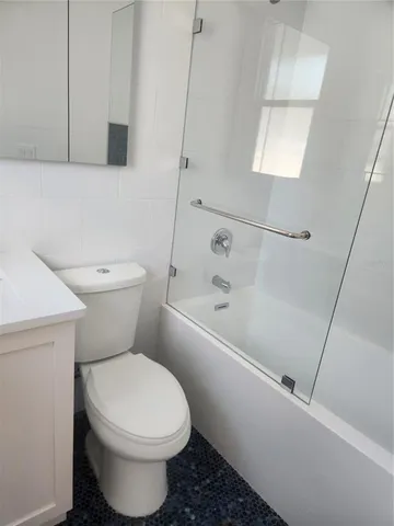 a white toilet sitting next to a bath tub