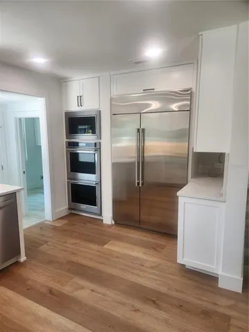 a kitchen with a refrigerator and a stove top oven