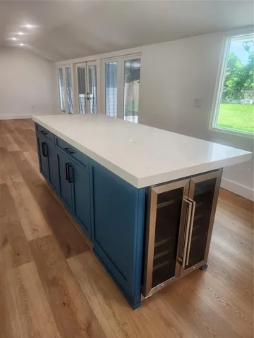 a kitchen with kitchen island wooden floor and window